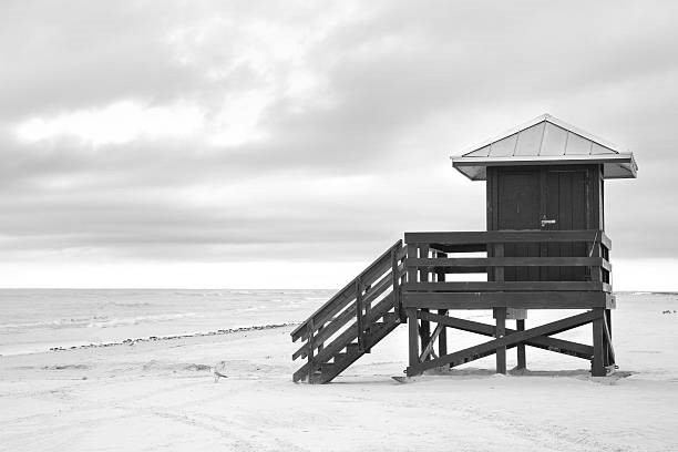 A blue lifeguard hut on an empty beach.